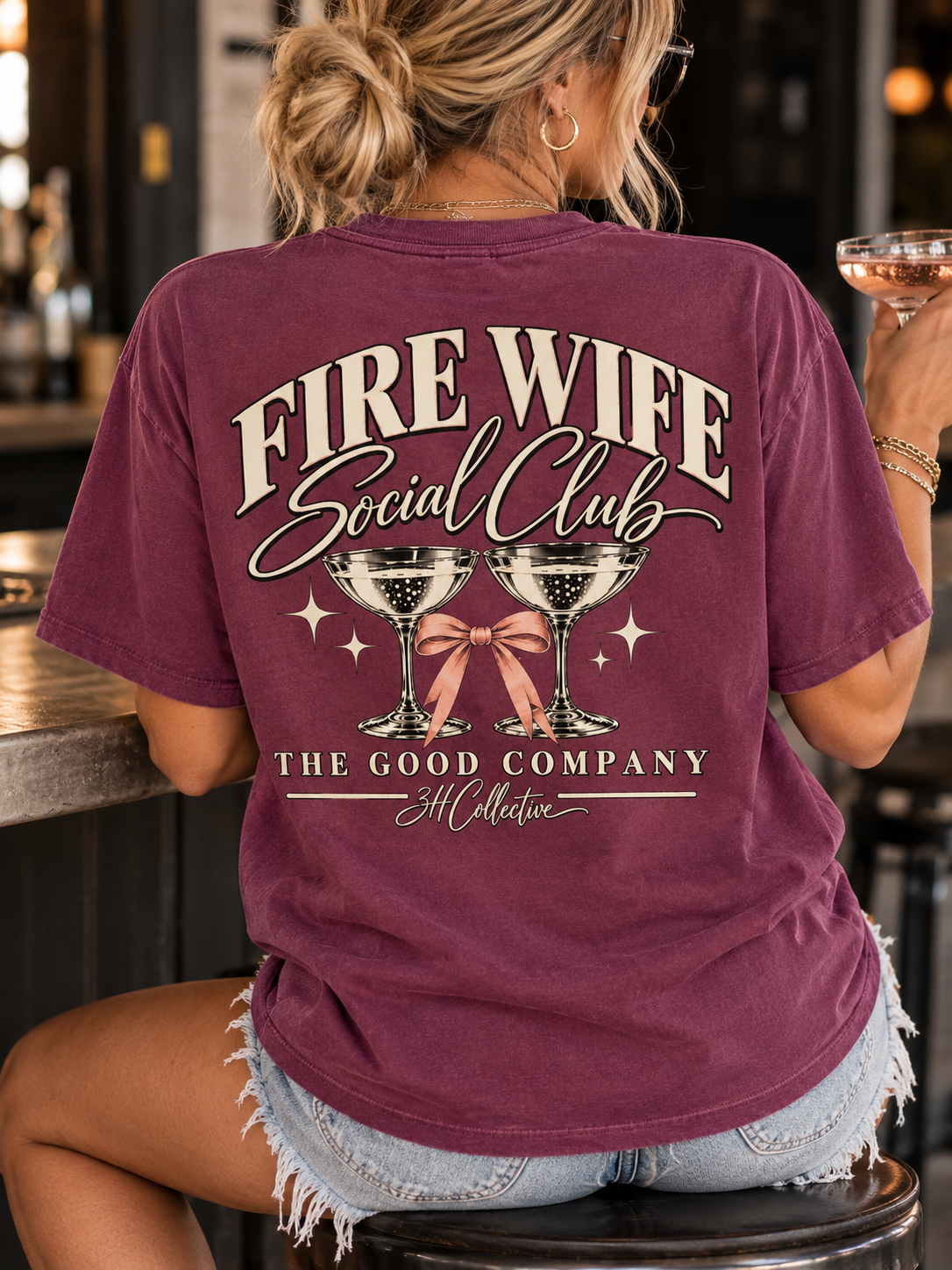 Woman wearing a vintage burgundy Fire Wife Social Club graphic tee by 3H Collective, featuring retro cream lettering and a pink bow design.