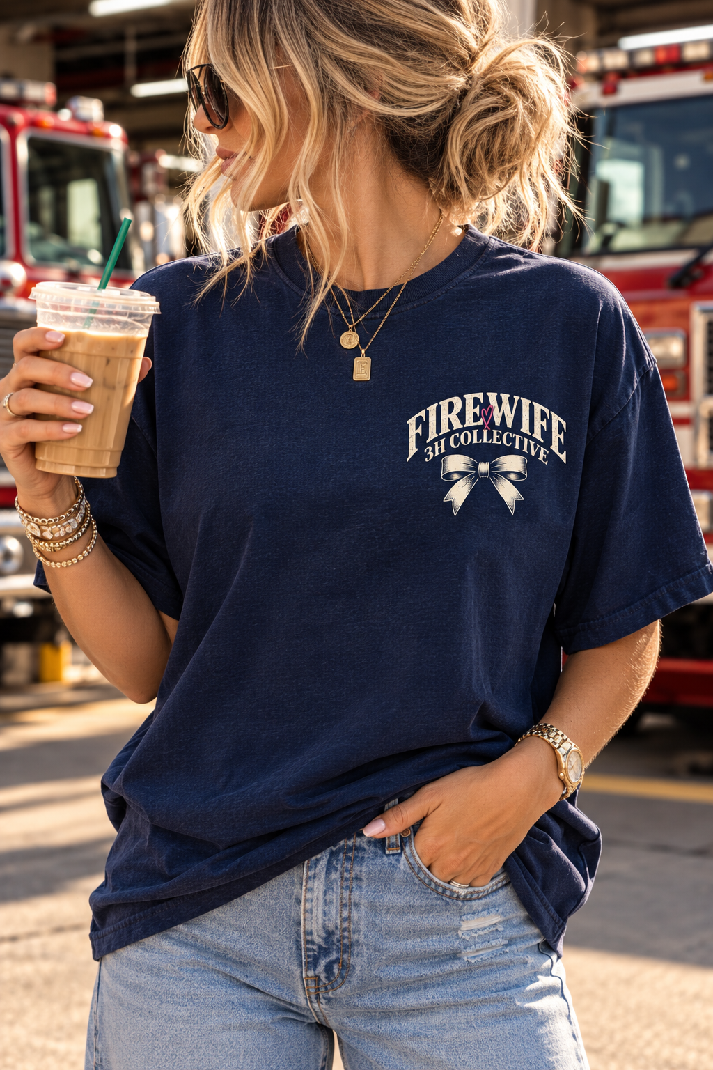 Woman wearing a vintage navy Fire wife graphic tee by 3H Collective, featuring a detailed firehouse, Dalmatian, pink heart, and “The Shift Ends. The Group Chat Begins.” back design.